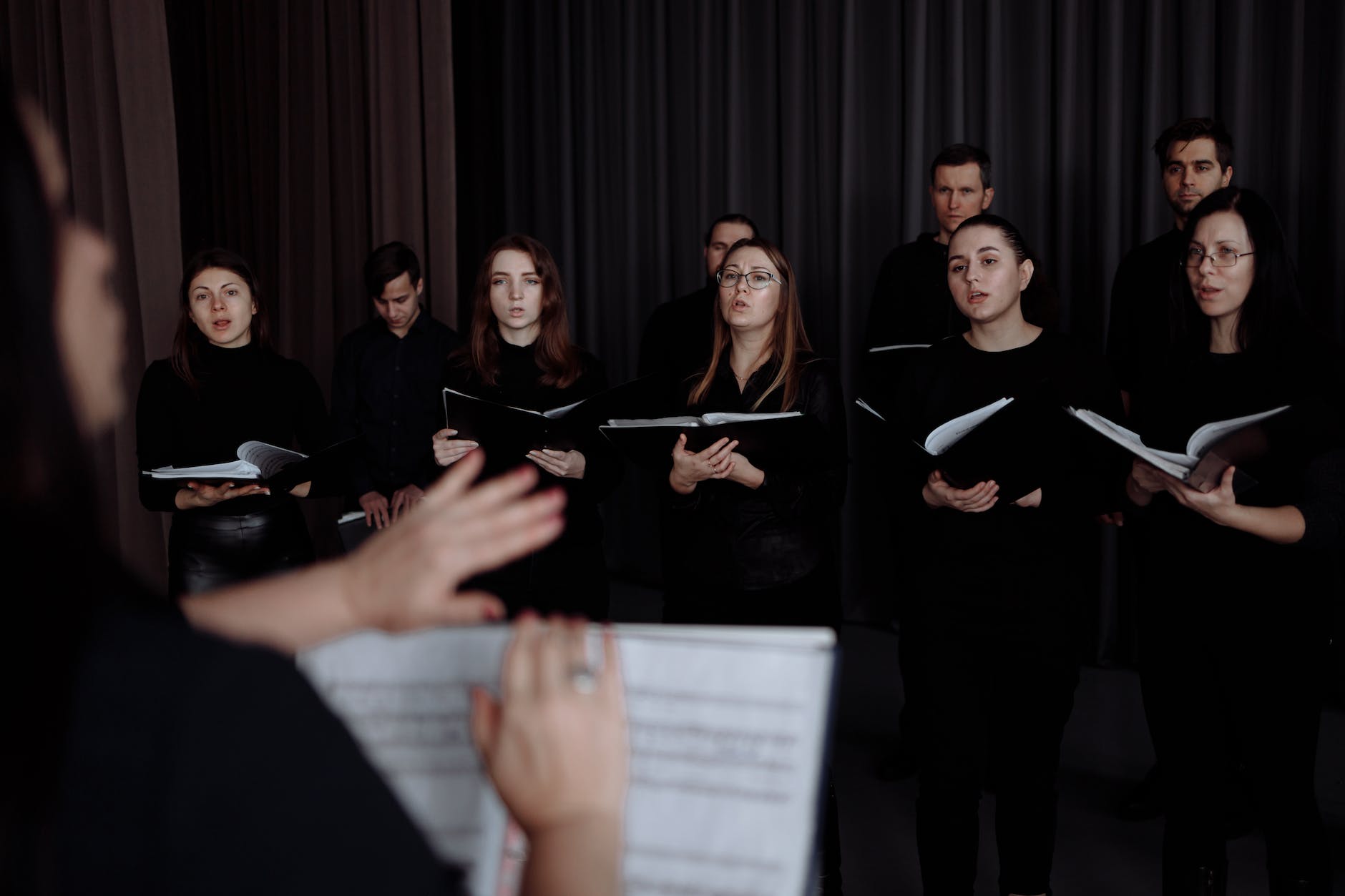 a choir singing while holding music sheets