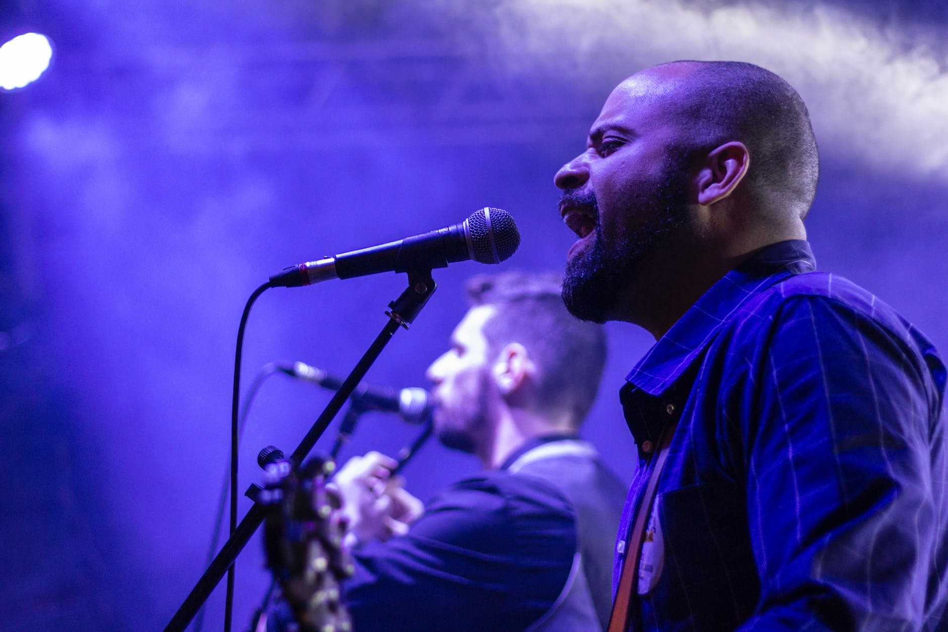 man singing in front microphne