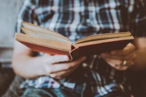 person reading book while sitting