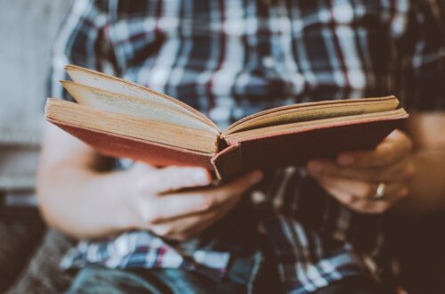 person reading book while sitting